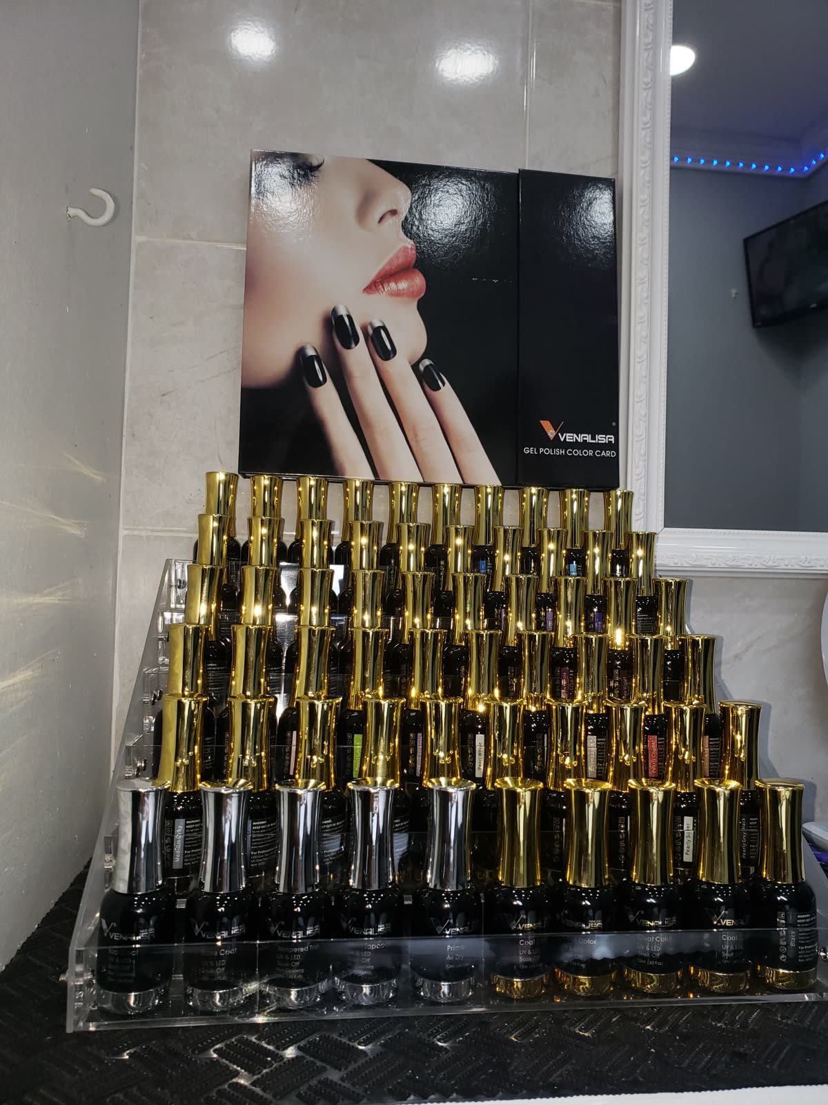 A pyramid of gold-capped gel polishes at the nail bar
