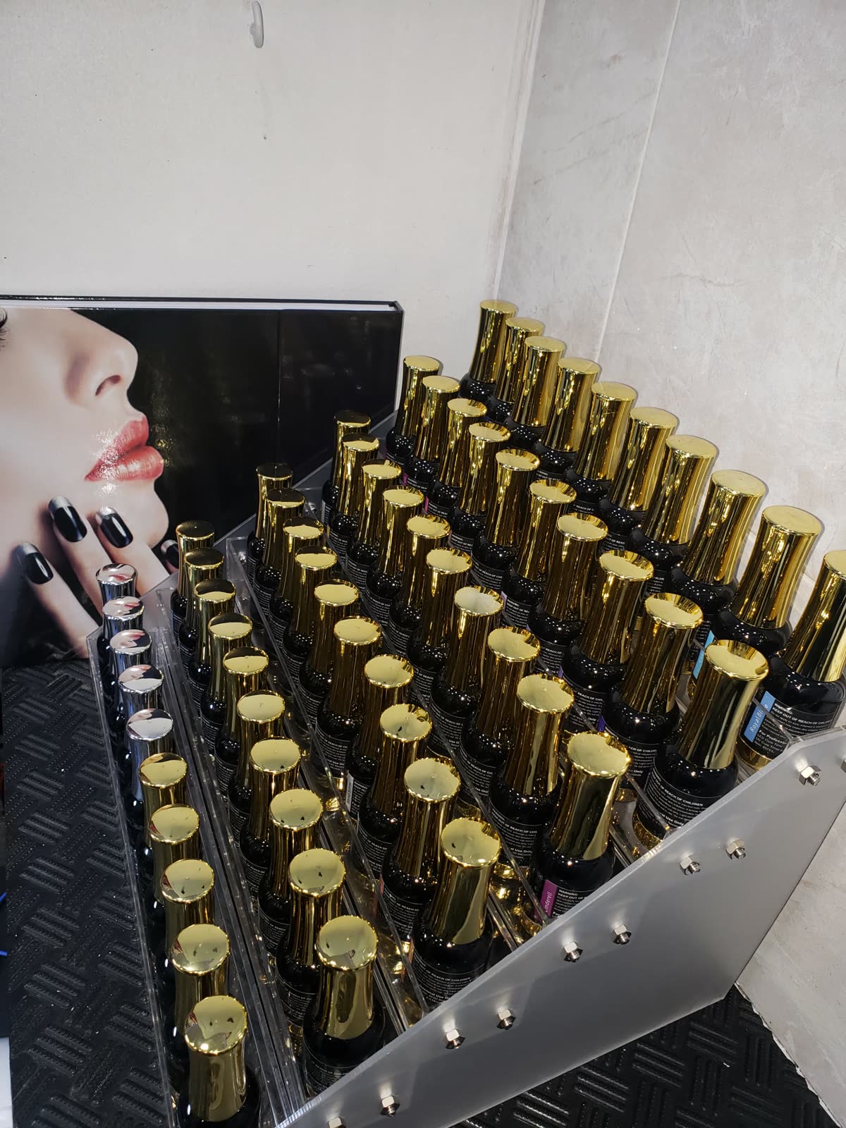Rows of gold-capped gel polish bottles on the salon's nail display